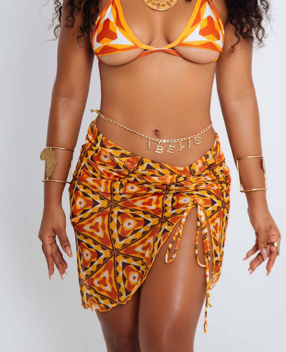 Falda malla Ori – prenda de playa afro corta con estampado kente en tonos tierra, cintura elástica y corte en forma de A, diseñada por Ibeyis en Cartagena