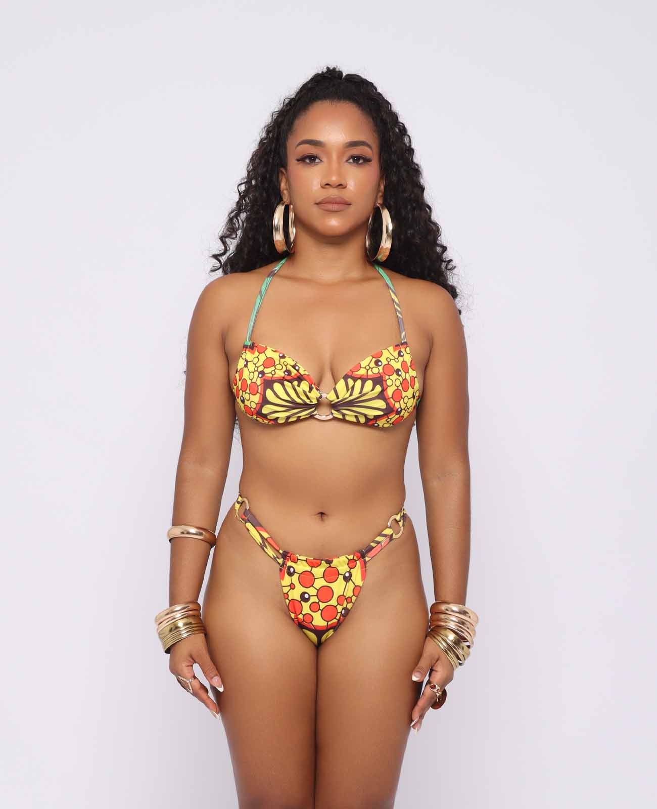 Aisha – bikini dos piezas afro con top bandeau y braguita media, estampado kente en tonos cálidos, diseñado por Ibeyis en Cartagena