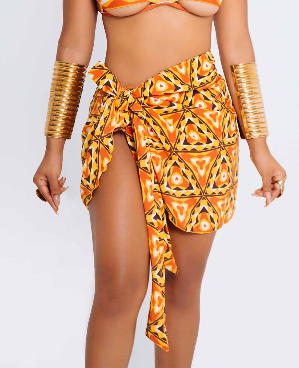 Pareo Ori – prenda de playa afro larga con estampado kente en tonos tierra, borde desflecado y cierre de nudo, diseñado por Ibeyis en Cartagena