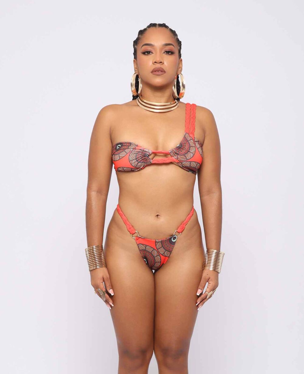 Vestido de baño enterizo afro estampado kente en tonos rojo-anaranjado, escote cruzado y cintura anudable, modelo Ibeyis Uzuri